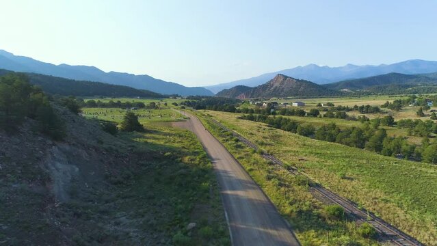 Aerial of mountain road by a railroad with a runner