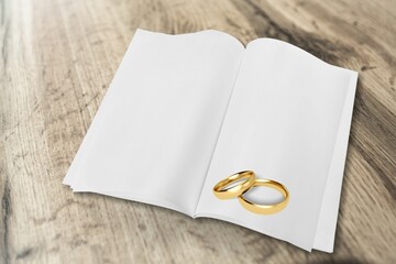 Two wedding rings on a blank marriage contract at a traditional wedding.