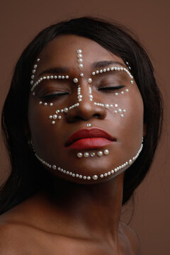 Vertical close-up of beautiful African black woman with pearls on her skin.