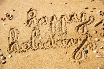 happy holidays writing on the beach