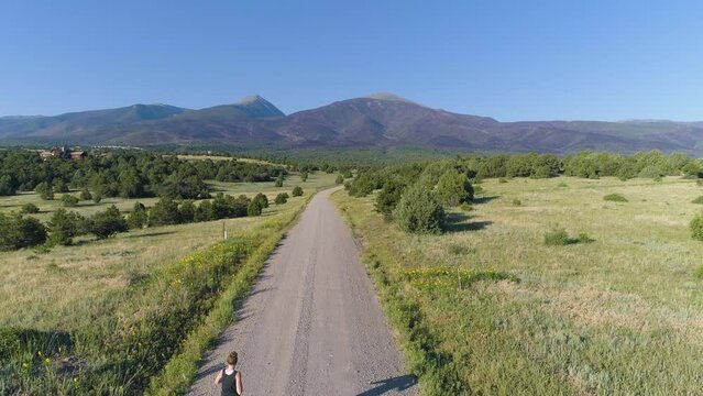 Aerial of runner on a road in the mountains in USA