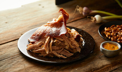 Hornado, a typical Ecuadorian dish that consists on pork cooked on firewood. It’s served on a...