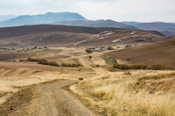 Fototapeta na wymiar Travel to Lesotho. A dirt track goes deep into the mountains towards the Sehlabathebe National Park