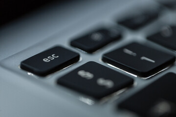 Fototapeta premium Modern computer keyboard with backlit and focus on the esc button, macro photo