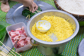 Making chung cake - A traditional food in Tet holiday- Vietnam including green beans, glutinous rice, pork, and pepper wrapped in dong leaves, passed down through generations.