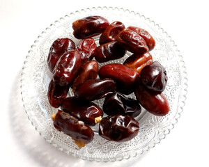 Dates on a glass plate with white background,high antioxidants and high fiber,eat as a snack