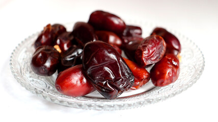 Date on a glass plate with white background,healthy dry food