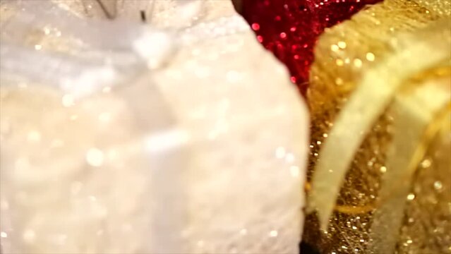 Christmas gift holiday decoration concept. Glitter sparkly presents tied with a bow red, gold, white, silver, shallow depth of field, 