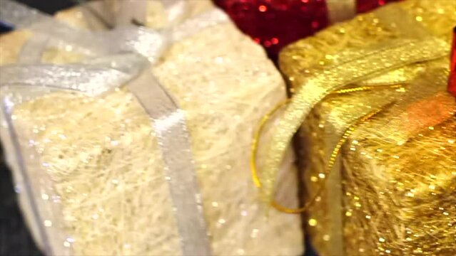 Christmas gift holiday decoration concept. Glitter sparkly presents tied with a bow red, gold, white, silver, shallow depth of field, 