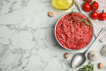 Fresh minced meat and other ingredients on white marble table, flat lay. Space for text