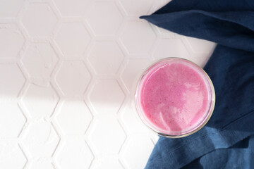 Pink rose milk with blue textile. Healthy drink moon milk. Copy space.