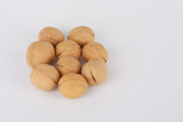 Walnuts on a white background are laid out in the shape of a flower