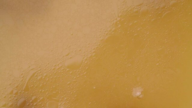 Drops falling onto the surface of bone broth and waves forming on it