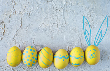 yellow easter eggs on textured background. Top view. Copy space