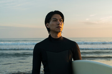 Fototapeta premium 朝の海でサーフィンをする男性