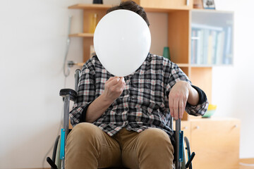 Ältere Frau im Rollstuhl mit Luftballon