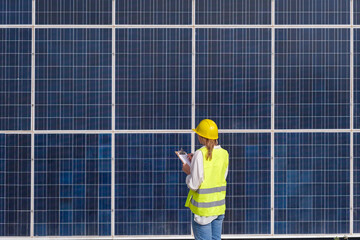 Woman with yellow helmet reviewing renewable energies