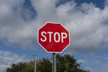 Stop sign with blue sky and white clouds in the background. 