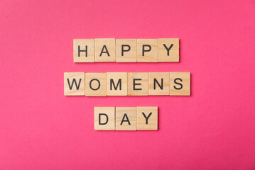 International Women's Day. Beautiful postcard for March 8. Happy women's day text on pink paper background. Holiday concept. Copy space. View from above.