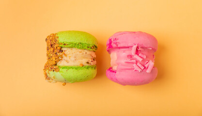 Delicious berry macaroons on a soft yellow-orange paper background. French meringue cookies macaron. Culinary and cooking concept. Copy space. top view.