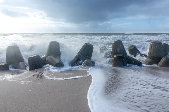 sea landscape with huge waves breaking a poller in Sylt