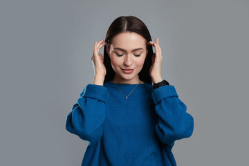 Portrait of beautiful young woman on grey background