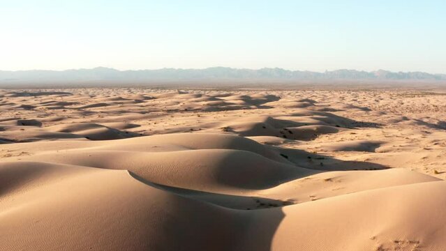 push in drone shot of sand dunes in the desert with mountains in the background - Aerial View of the Scenic Desert Landscape