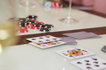 Laying out cards on the table in poker game. Glass of champagne. Gambling concept. Candid moment. Poker background photography. Selective focus.