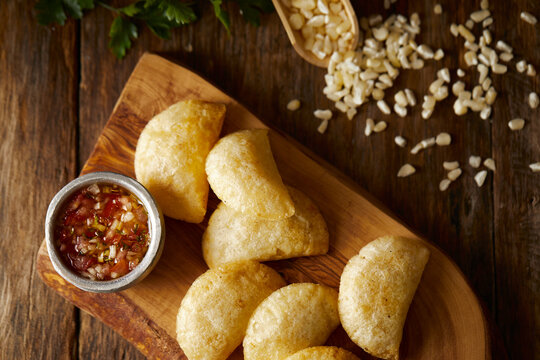 Empanadas de morocho, a typical ecuadorian dish served with chilli and on a wooden and traditional background. 