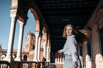 Young smiling Caucasian woman turning back sightseeing in Europe