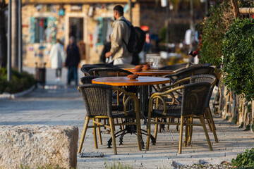 Atmospheric summer photography. Wooden cafe chairs  on table. Outdoor street cafe
