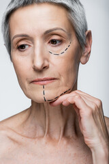 mature woman with wrinkles and marked lines on face isolated on grey
