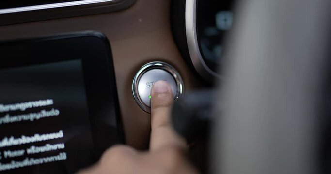 Close up of Man presses start button in car motor. Turning on functioning systems vehicle. Start using car before driving, start electronic systems in car.