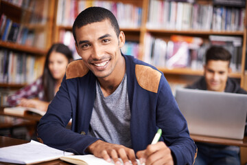 Hes such a diligent student. Cropped portrait of a handsome young student working diligently in his...