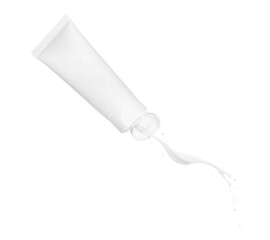 Cream pours out of the tube in the air on a white background