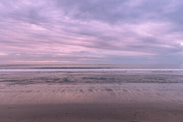 Pacific Ocean waves breaking onto the California coast at sunset