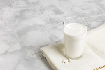 Kefir fermented milk drink with kefir mushrooms. Homemade kefir in a glass next to natural capsules. Selective focus. The concept of healthy eating.