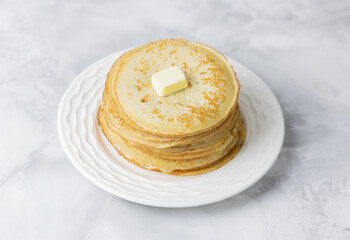 homemade pancakes stacked with butter on a white plate. Selective focus.