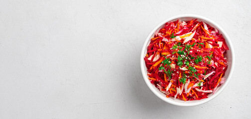 Beetroot salad with cabbage and carrots seasoned with dill and sesame seeds.