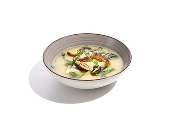 Japanese food - miso soup with tofu, wakame and shiitake mushroom. Vegetarian miso soup in ceramic bowl on isolated white background.