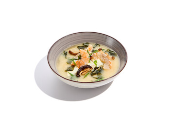 Japanese food - miso soup with tofu, wakame, prawn and shiitake mushroom. Miso soup with shrimp in ceramic bowl on isolated white background.