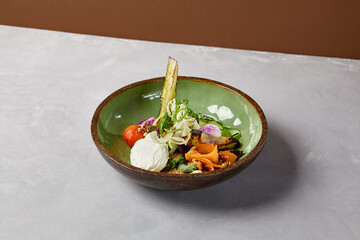 Salad bowl with salmon, avocado, broccoli, vegetables and egg on homemade ceramic plate. Buddha bowl with salmon, broccoli, quinoa in modern serveware. Modern ceramic dishware on concrete background.