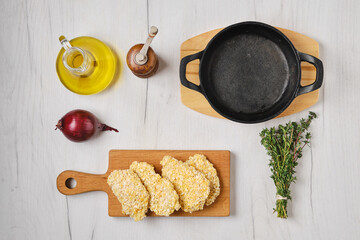 Overhead view of chicken nuggets in breading ready for frying