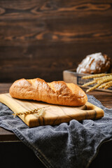 Fresh wheat bread on wooden cutting board
