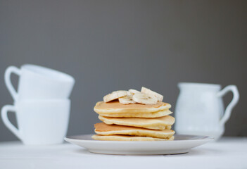 Tasty pancakes with blackberries, banana, raspberries, eggs, honey and maple syrup on wooden background. Morning breakfast concept.