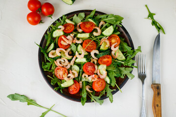 Pouring Olive oil on fresh Vegetable salad, mediterranean cuisine, Greek salad, white table served with healthy food ingredients
