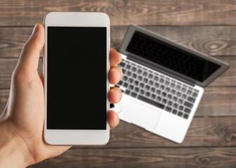 Male hand holding a smartphone with a blank screen