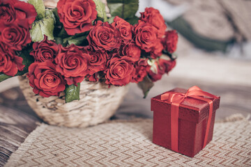 the concept of the holiday. gift in red box and bouquet of roses