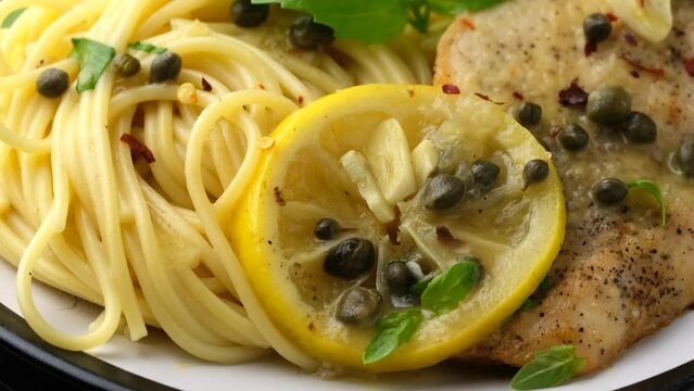 Chicken Piccata with capers, white wine sauce and spaghetti. Rotating video