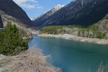 Embalse de Paso Nuevo  bajo las nevadas montañas, en el Valle de Benasque, en el corazón del Pirineo Aragonés, Huesca, España.